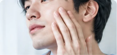頬に手を添える男性の肌のイメージ